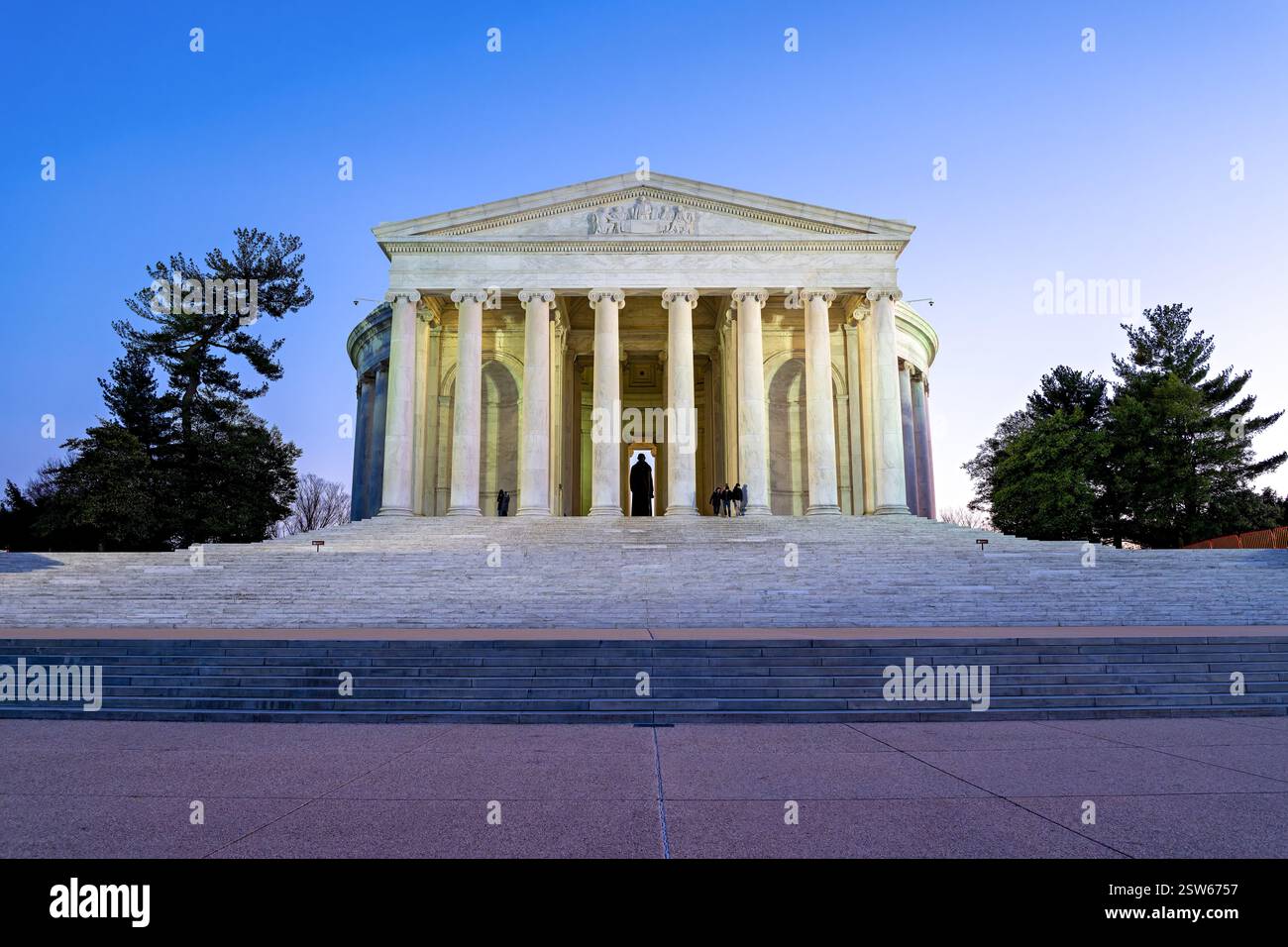 WASHINGTON DC – die vordere Fassade und die Stufen des Thomas Jefferson Memorial werden in der Abenddämmerung entlang des Tidal Basin beleuchtet. Das neoklassizistische Denkmal verfügt über einen Portikus mit ionischen Säulen, die ein Kuppeldach tragen. Das vom Architekten John Russell Pope entworfene Denkmal wurde 1943 zu Ehren des dritten amerikanischen Präsidenten geweiht. Stockfoto