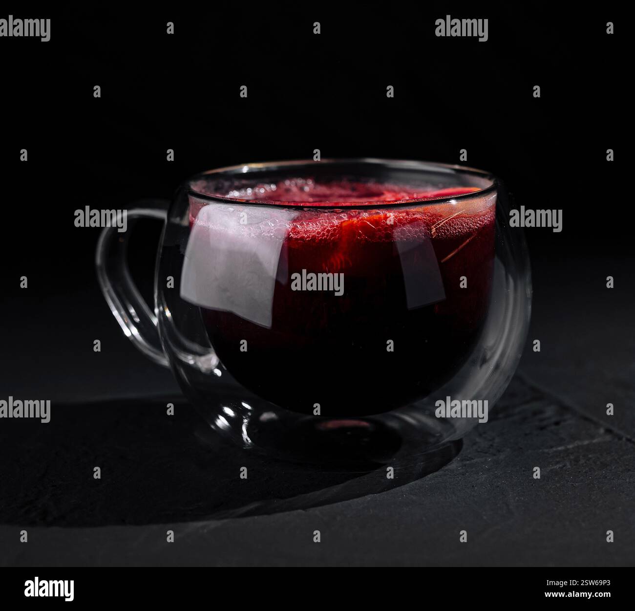 Elegantes Glas roten Tees auf dunklem Hintergrund Stockfoto