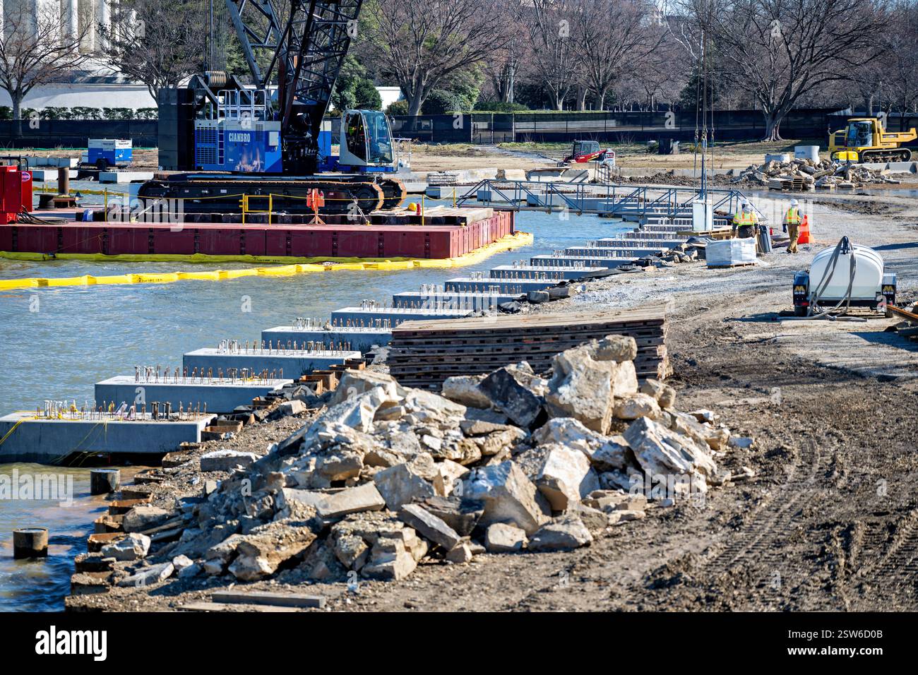 WASHINGTON DC, USA – Baumaschinen und temporäre Barrieren markieren die laufenden Arbeiten am Tidal Basin Reconstruction Project, wie sie am 14. Februar 2025 fotografiert wurden. Die umfangreiche Renovierung zielt darauf ab, die seit langem bestehenden Probleme der Siedlung, Erosion und Überschwemmung rund um das historische Becken zu lösen. Das mehrjährige Projekt, das vom National Park Service verwaltet wird, umfasst den Wiederaufbau der Meeresmauer, die Verbesserung der Entwässerungssysteme und den Schutz der berühmten Kirschbäume, die den Rand des Beckens säumen. Stockfoto