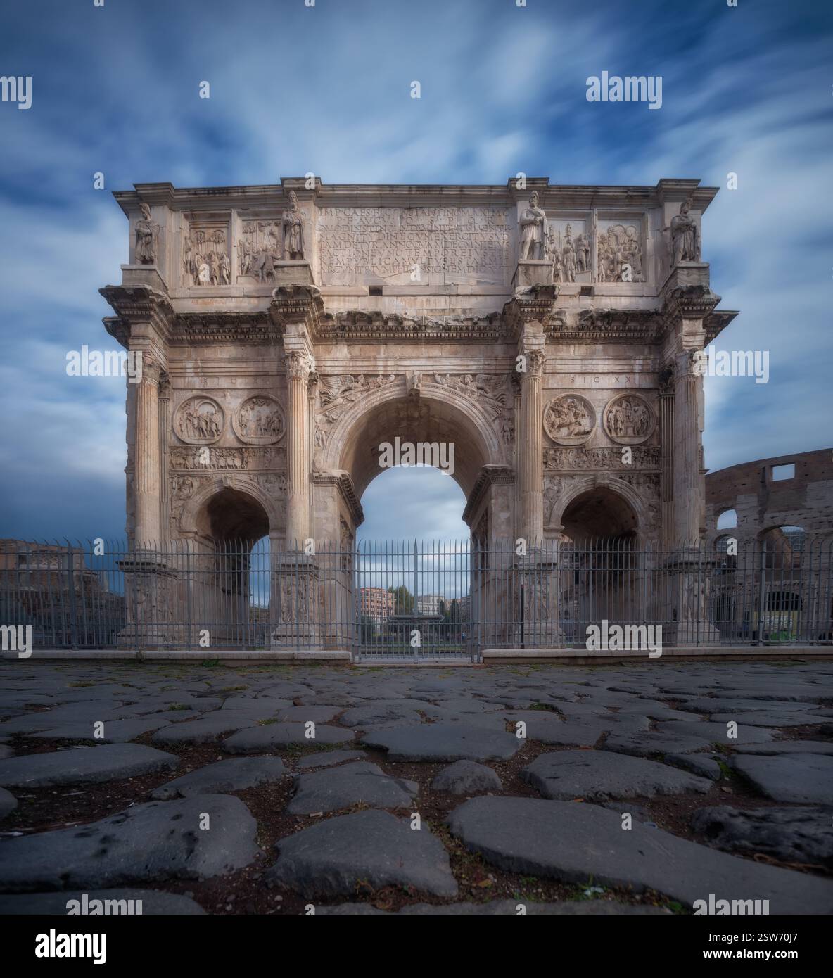 Konstantinbogen, Rom: Blick auf Augenhöhe, antike römische Architektur, kunstvolle Schnitzereien, Kopfsteinpflaster im Vordergrund. Stockfoto