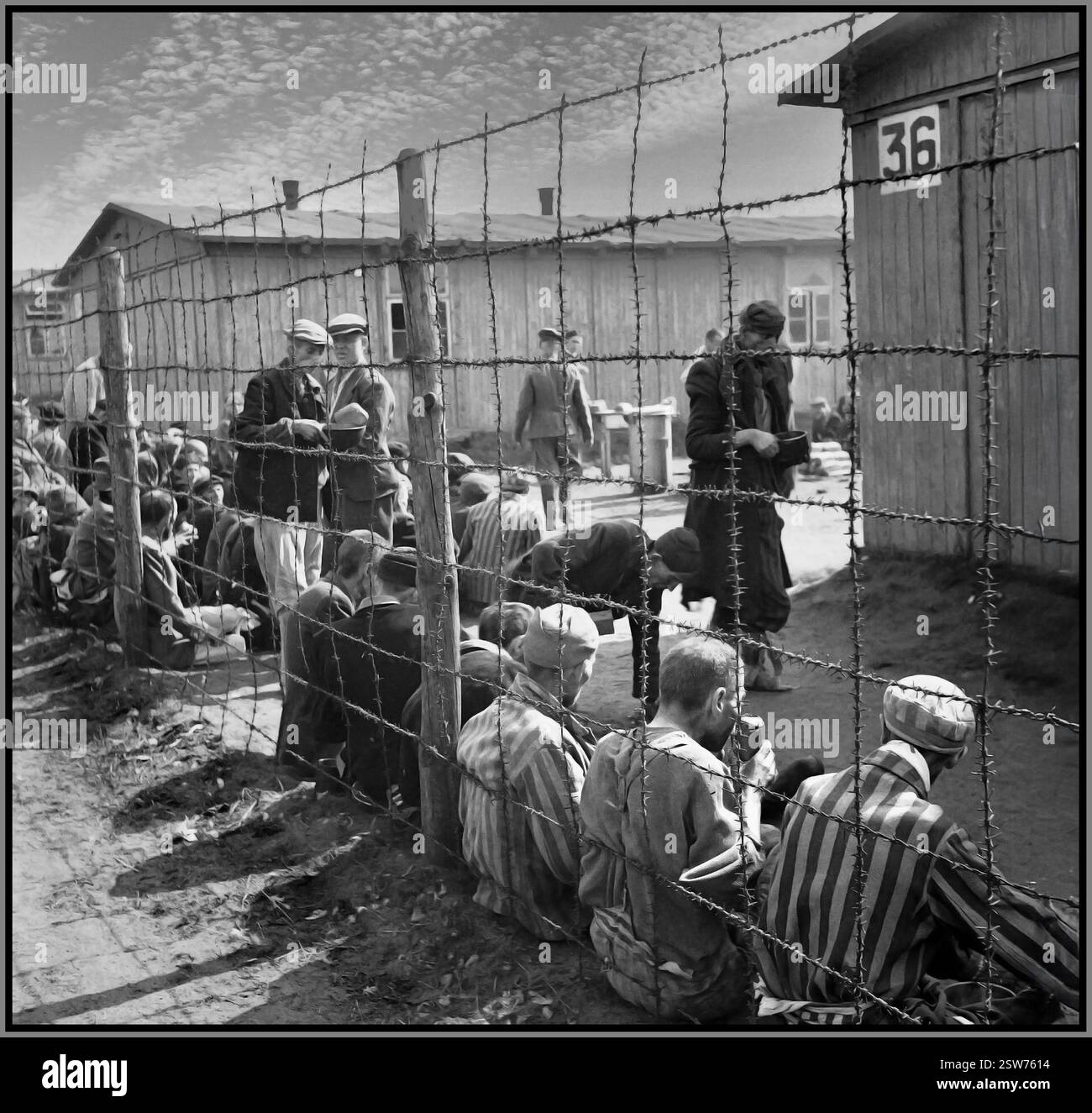 Die Befreiung des Konzentrationslagers Bergen-Belsen, April 1945 Gefangene sitzen am Drahtzaun, der die verschiedenen Teile des Lagers trennt. Sie essen ihre erste Mahlzeit nach der Befreiung des Lagers. Datum 1945 das Konzentrationslager Bergen-Belsen wurde am 15. April 1945 von britischen Truppen befreit. Zur Zeit der Befreiung befand sich das Lager in einem Zustand katastrophaler Vernachlässigung – überfüllt, reich an Krankheiten (insbesondere Typhus) und überfüllt mit Tausenden unbegrabener Leichen. Stockfoto