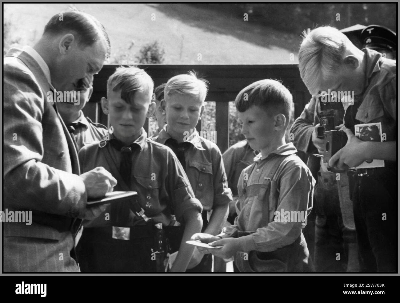 Adolf Hitler gibt Autogramme und lässt sich von Jungen der Hitlerjugend in Uniform fotografieren, auf seinem Landsitz der Berghof Obersalzberg Bayern 1935 aus dem Propagandabuch „(die Jugend des Führers Adolf Hitler“) Stockfoto
