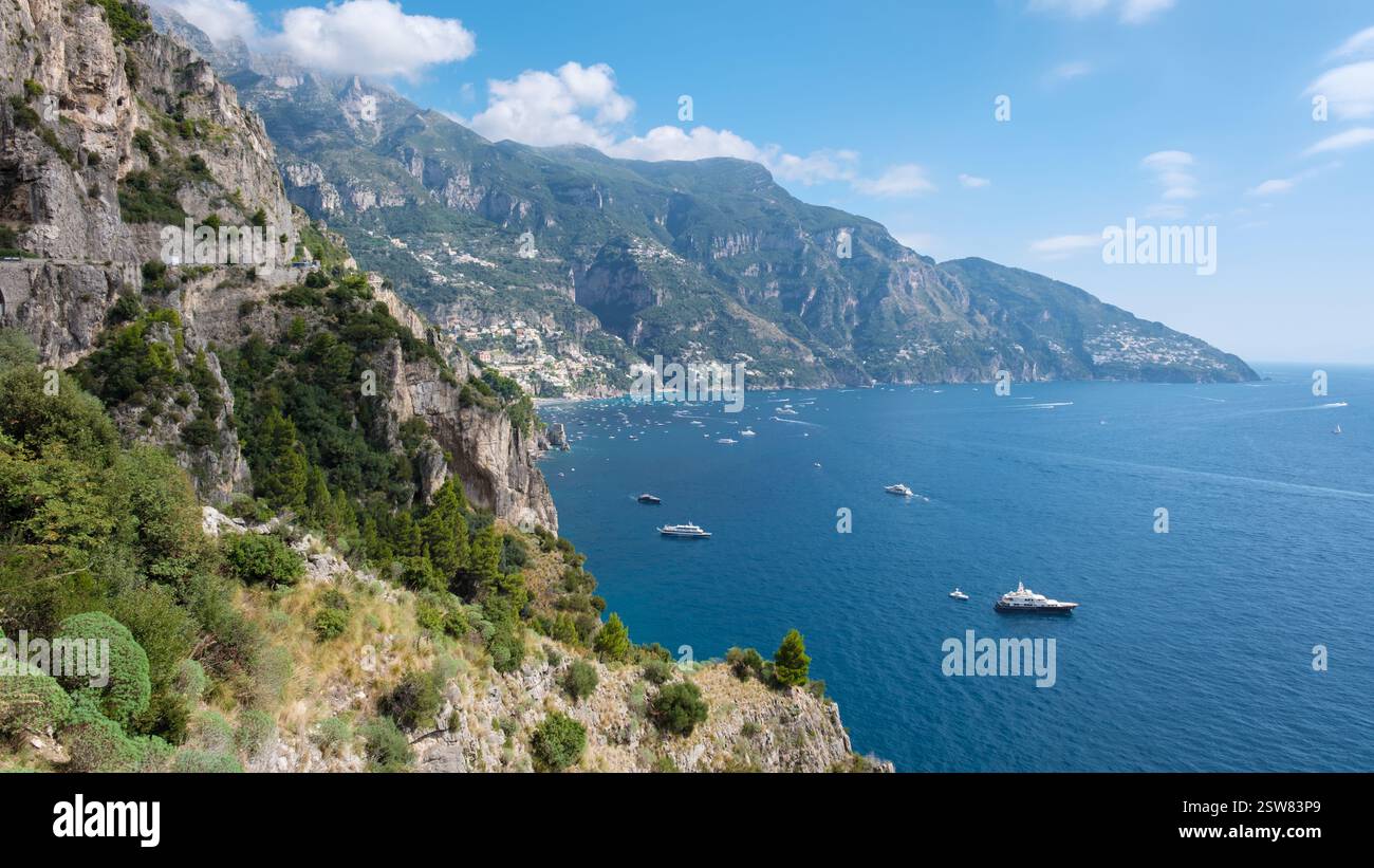 Atemberaubender Blick auf die Amalfiküste mit azurblauem Wasser und üppigen Klippen unter hellem Himmel Stockfoto