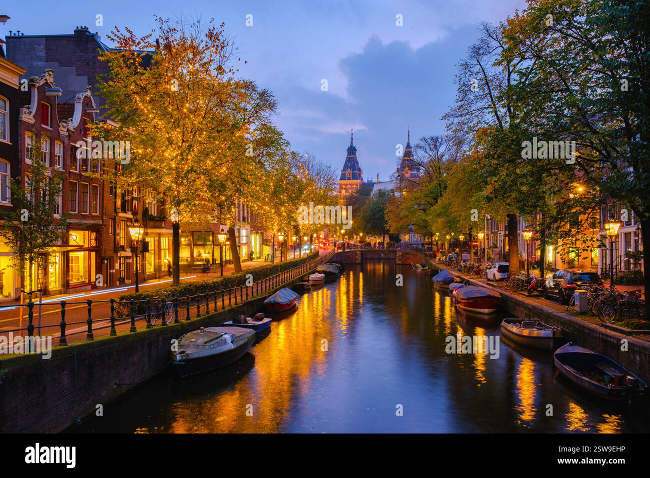 Amsterdams bezaubernde Kanäle während der Weihnachtszeit mit lebhaftem Laub und warmen Lichtern Stockfoto