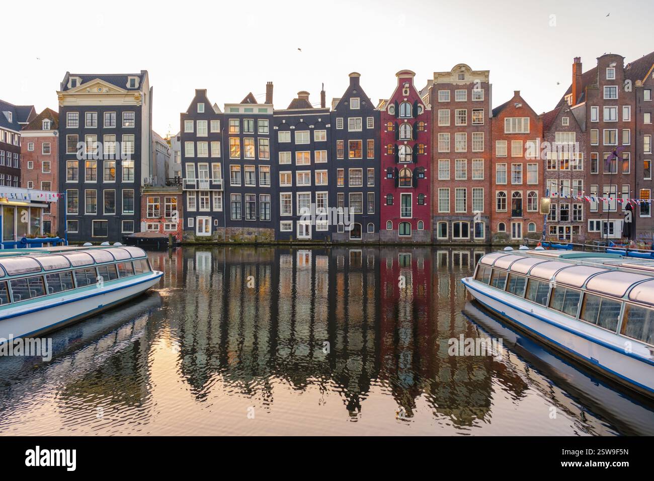 Erkunden Sie die ruhigen Kanäle von Amsterdam im Herbst mit malerischen Reflexionen in der Abenddämmerung Stockfoto