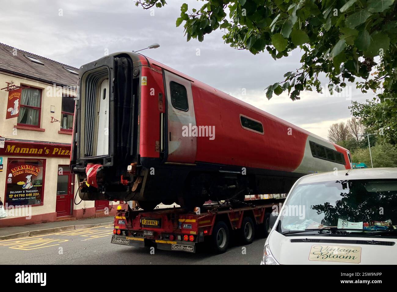 Ein BR Mark 4 Passagierwagen auf einem Tieflader, der nach dem Verlassen des Landore Depots durch das Hafod in Swansea gefahren wird. Oktober 2023. Stockfoto