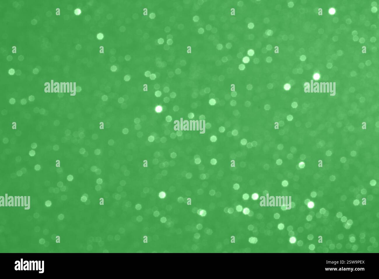 Grüner, defokussierter Glitzer-Bokeh-Hintergrund mit funkelnden und schimmernden Partikeln Stockfoto