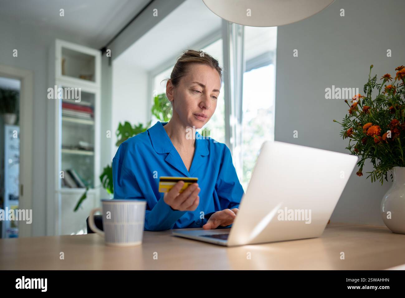 Eine Frau, die sich auf Notebooks konzentriert, verwendet eine Kreditkarte für Online-Transaktionen, die durch hohe Ausgaben verloren geht. Kreditverbindlichkeiten Stockfoto