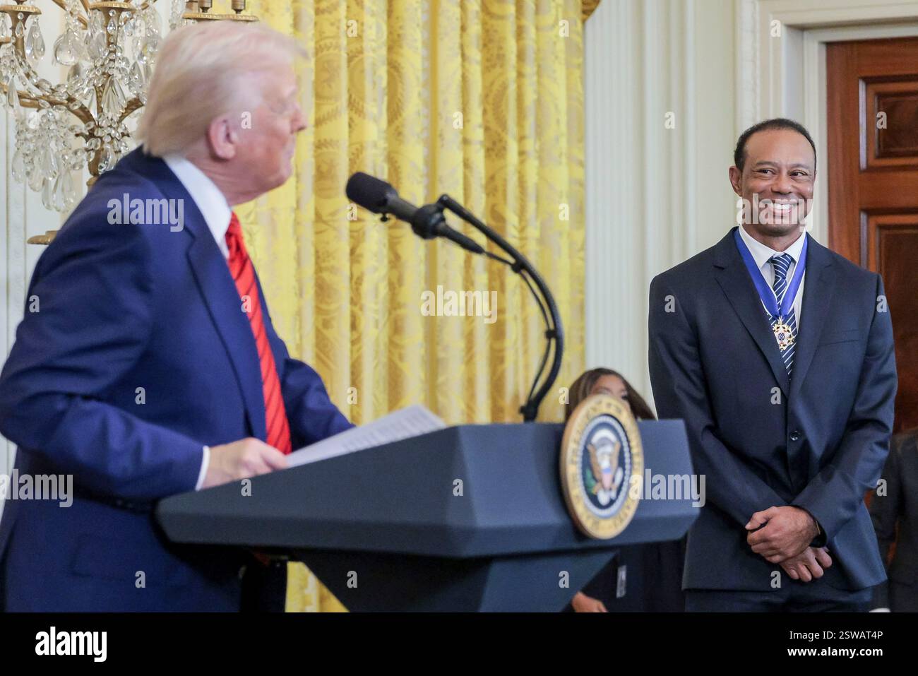 Washington, Usa. Februar 2025. Golfer Tiger Woods (R) hört US-Präsident Donald J. Trump (L) während eines Empfangs zu Ehren des Black History Month im East Room des Weißen Hauses in Washington, DC, USA, 20. Februar 2025. Quelle: SIPA US/Alamy Live News Stockfoto