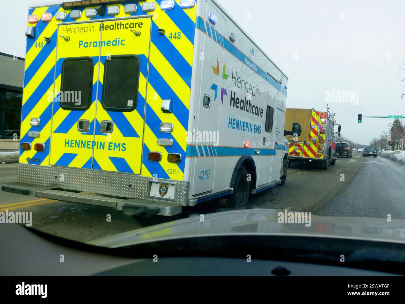 Hennepin County Healthcare Sanitäter-Krankenwagen folgt einem Feuerwehrauto die Straße runter. Minneapolis Minnesota MN USA Stockfoto