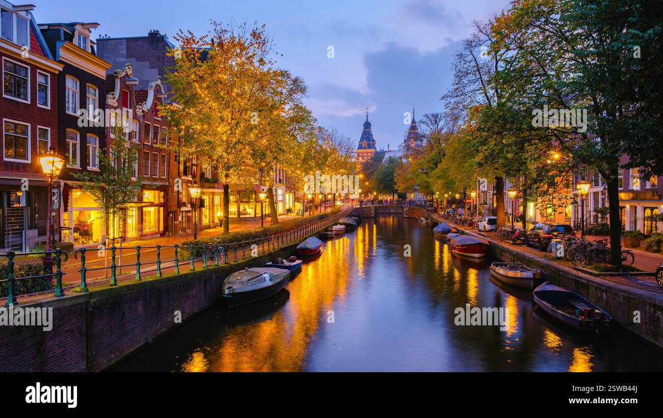 Herbstabende in Amsterdam mit Reflektionen auf die ruhigen Kanäle und die goldbeleuchteten Bäume Stockfoto