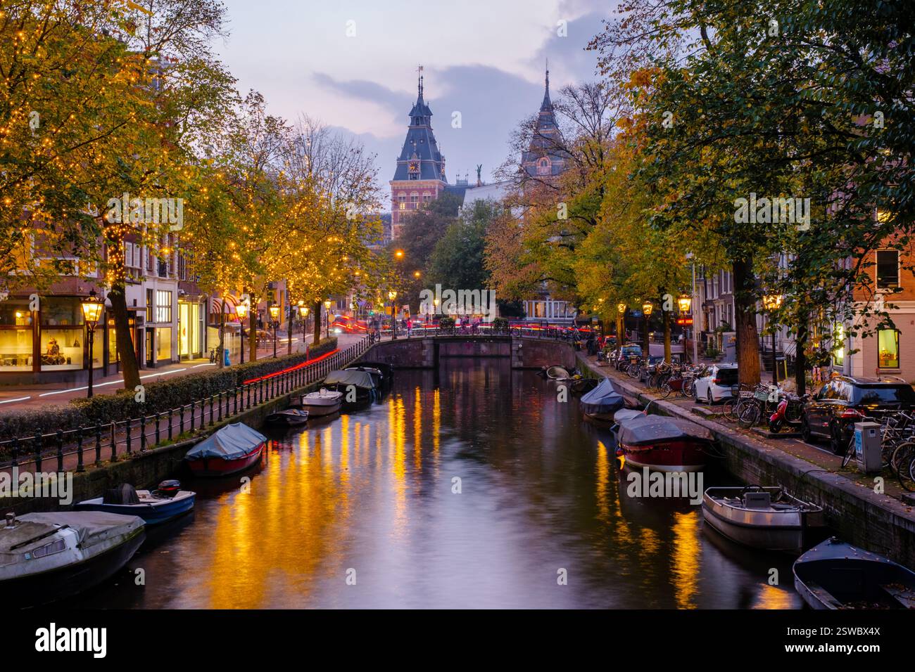 Zauberhafter Herbstabend entlang der Kanäle von Amsterdam, mit lebhaftem Laub und warmen Lichtern Stockfoto