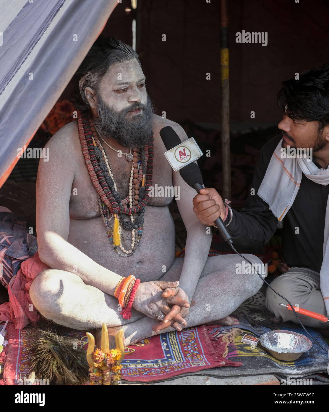 Ein Naga Sadhu, der während der Kumbh Mela in Prayagraj, Indien, ein Interview mit dem AV-TV-Sender gab. Stockfoto