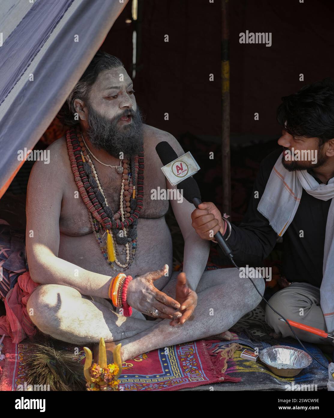 Ein Naga Sadhu, der während der Kumbh Mela in Prayagraj, Indien, ein Interview mit dem AV-TV-Sender gab. Stockfoto