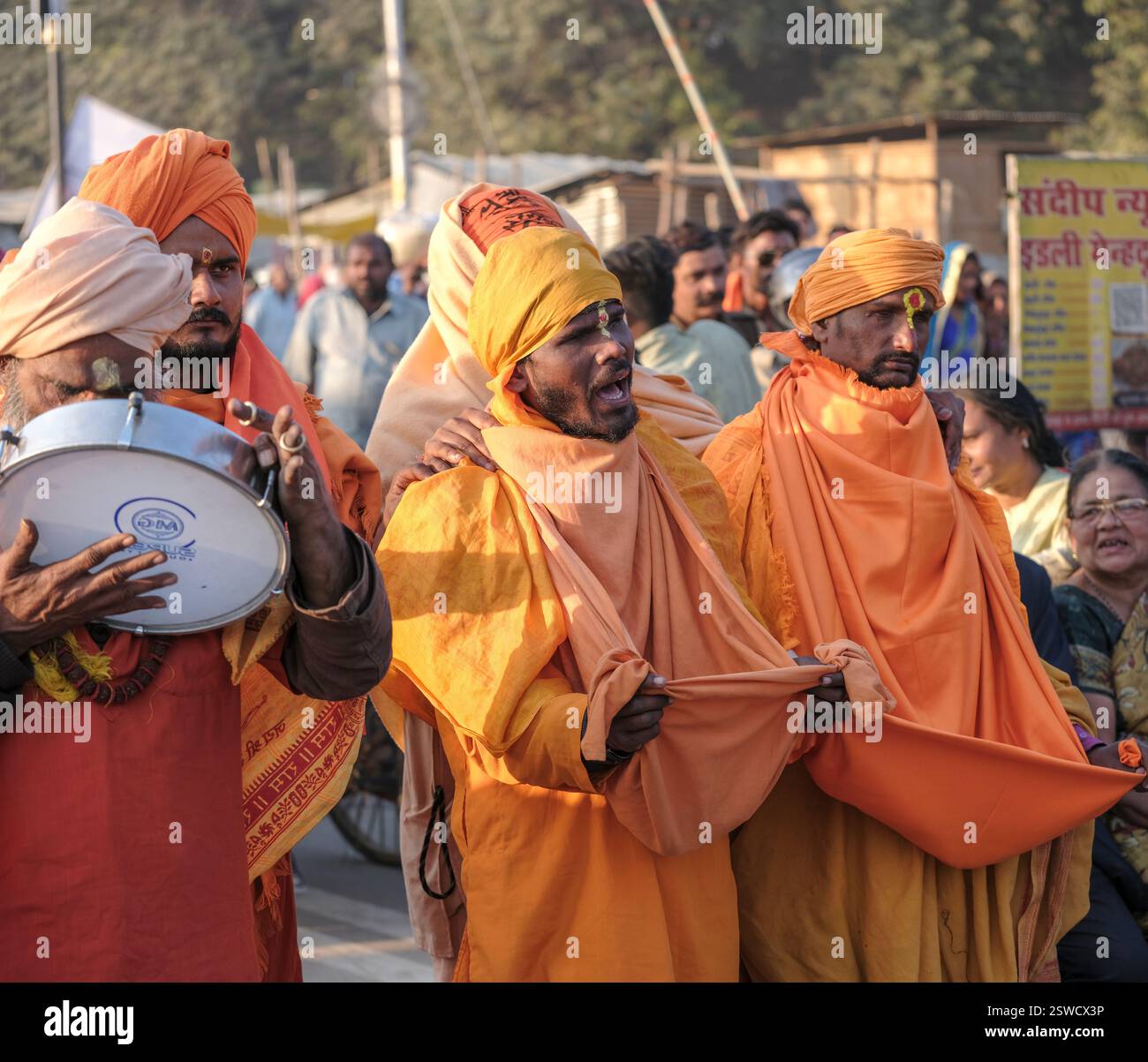Eine lebhafte Versammlung blinder Krishna sadhus sammelt Almosen im Maha Kumbh Mela in Prayagraj, Indien. Stockfoto