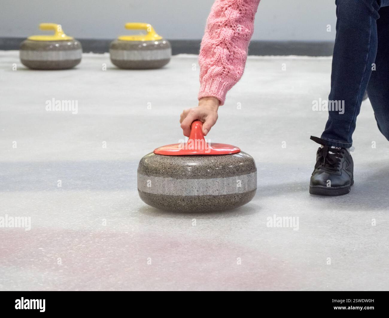 Stein zum Eisstockschießen auf einer Eisbahn Stockfoto