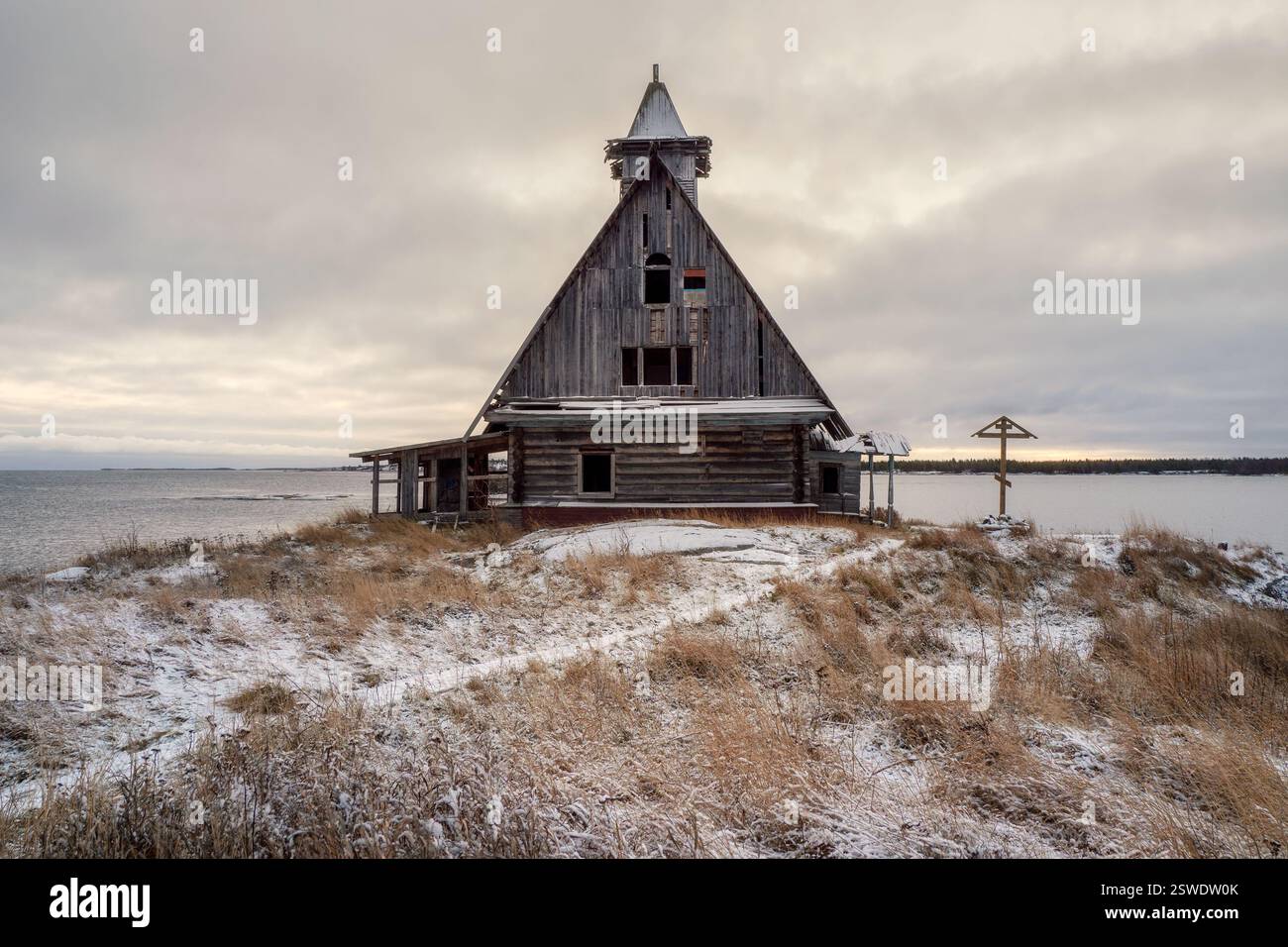 Verschneite Winterlandschaft mit authentischem Kinohaus am Ufer im russischen Dorf Rabocheostrowsk Stockfoto
