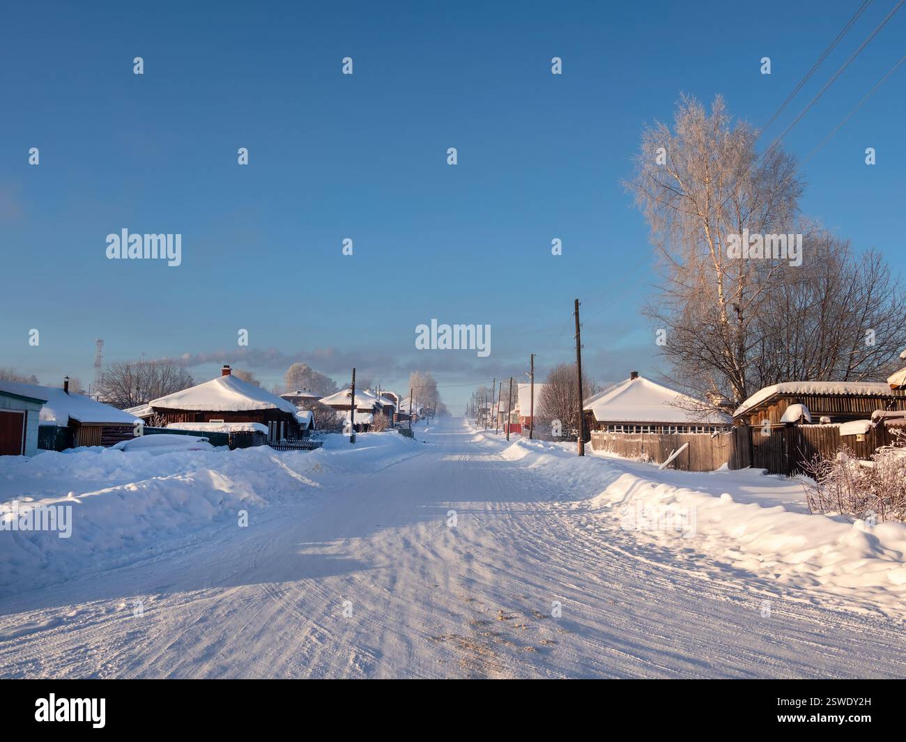 Schneebedeckte Straße auf dem Land mit Schneewehungen im frostigen Winter. Stockfoto