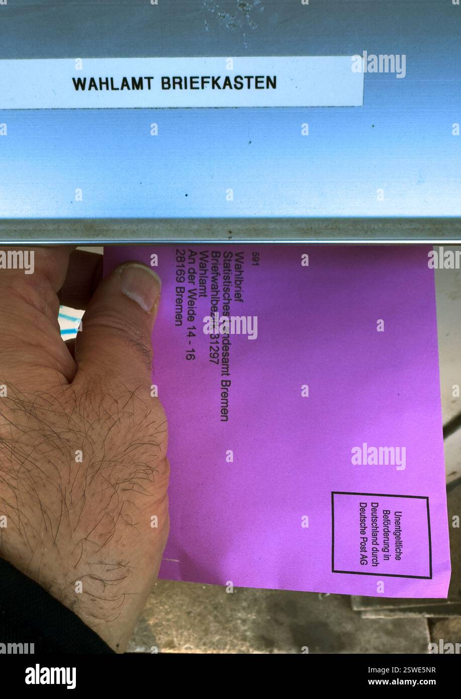19.02.2025, Deutschland, Bremen, Bremen - Wahlzettel für die Briefwahl, Bundestagswahl 2025, Einfügung der Briefwahl in den Briefkasten der Stockfoto