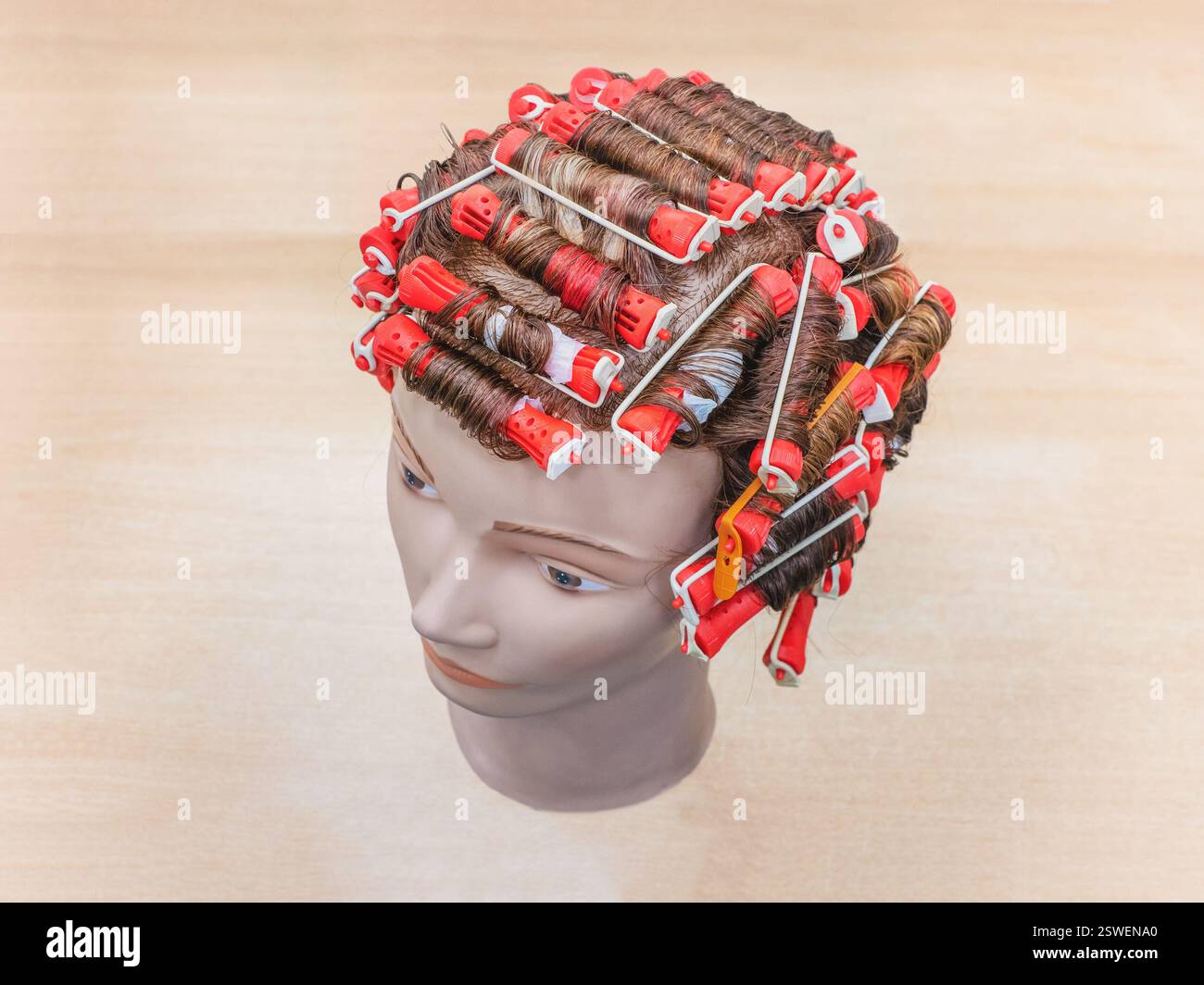 Perm-Training an einer Schaufensterpuppe in der Friseurschule Stockfoto