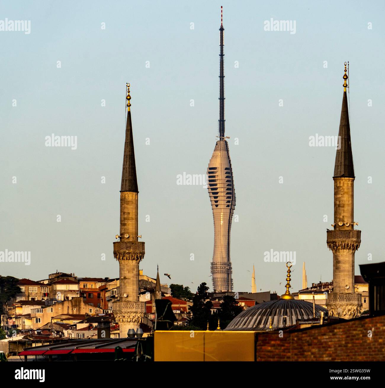 Ein Blick auf die Skyline mit zwei hohen Moscheenminaretten im Vordergrund und einem modernen Turm im Hintergrund, der die Mischung aus traditionellem und konischem Stil symbolisiert Stockfoto
