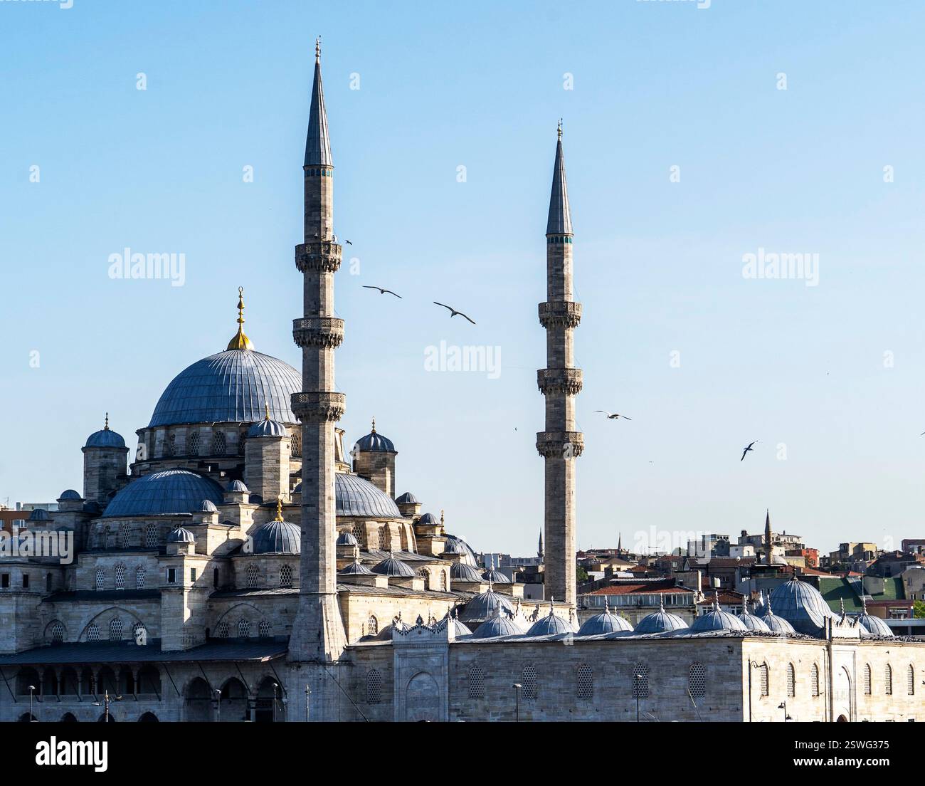 Ein atemberaubender Blick auf eine historische Moschee mit hohen Minaretten vor einem klaren blauen Himmel. Die architektonischen Details zeigen traditionelles islamisches Design, mit Stockfoto