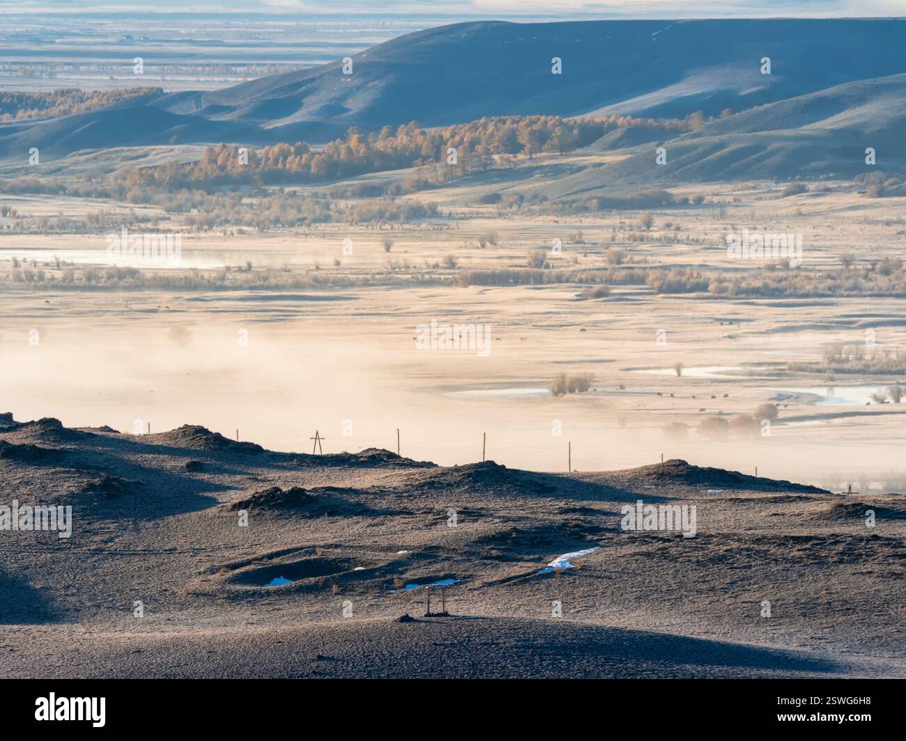 Nebliges Bergtal am Morgen. Tal mit dem Fluss in der Ferne Stockfoto