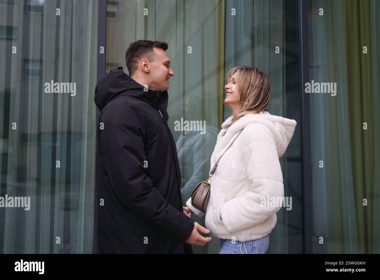Liebevolle Liebhaber lächeln einander zu Stockfoto
