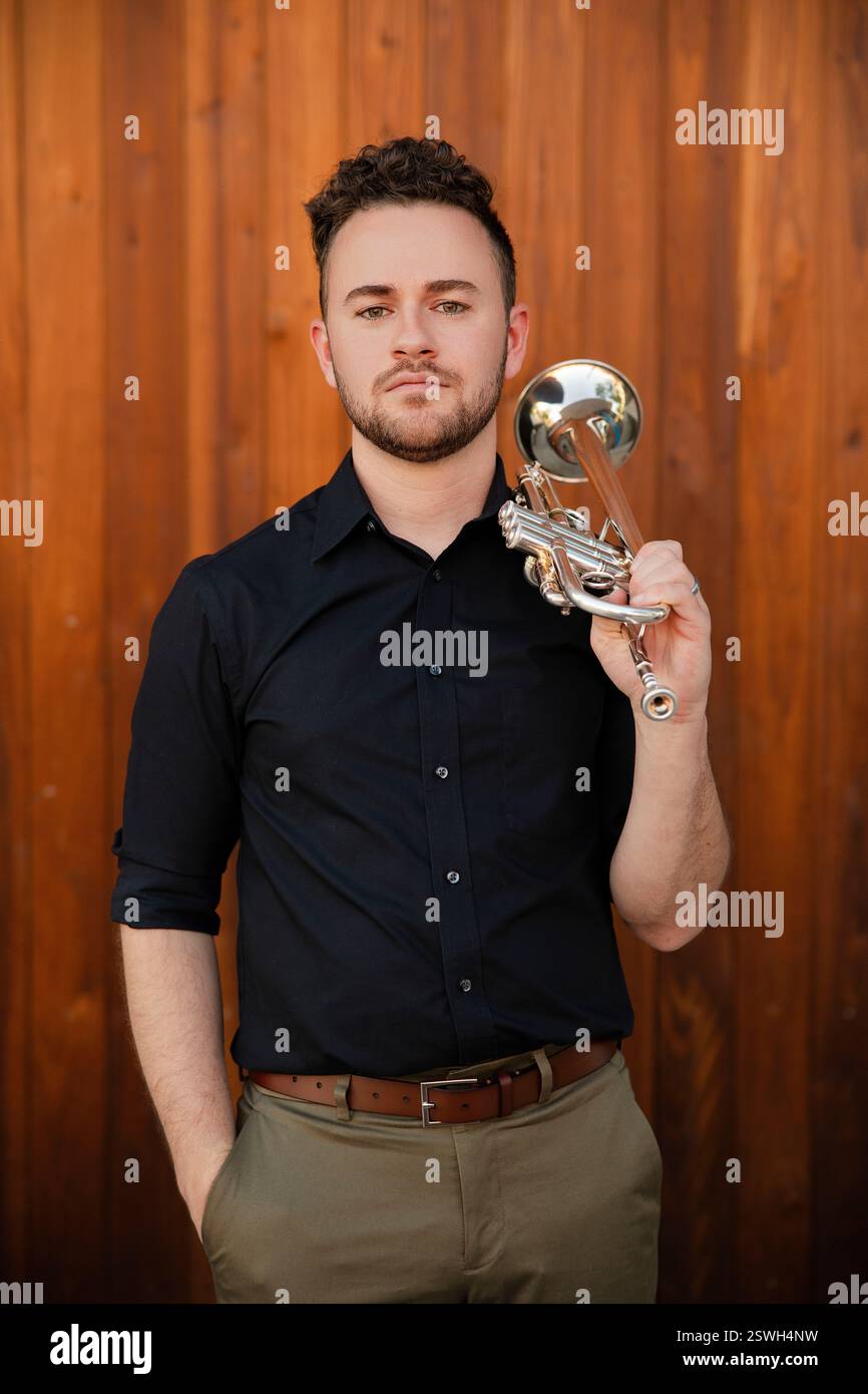 Souveräner Trompetenspieler vor hölzernem Hintergrund Stockfoto