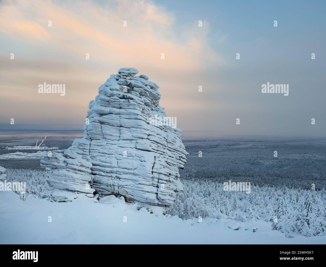 Großes Granitgestein ist gefroren und mit Schnee bedeckt. Naturstein Stockfoto