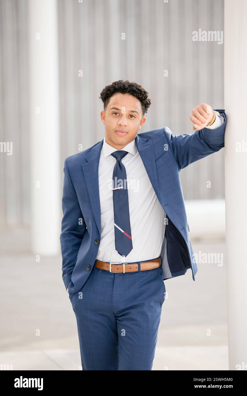 Professioneller Mann, der sich gegen den Stab lehnt Stockfoto