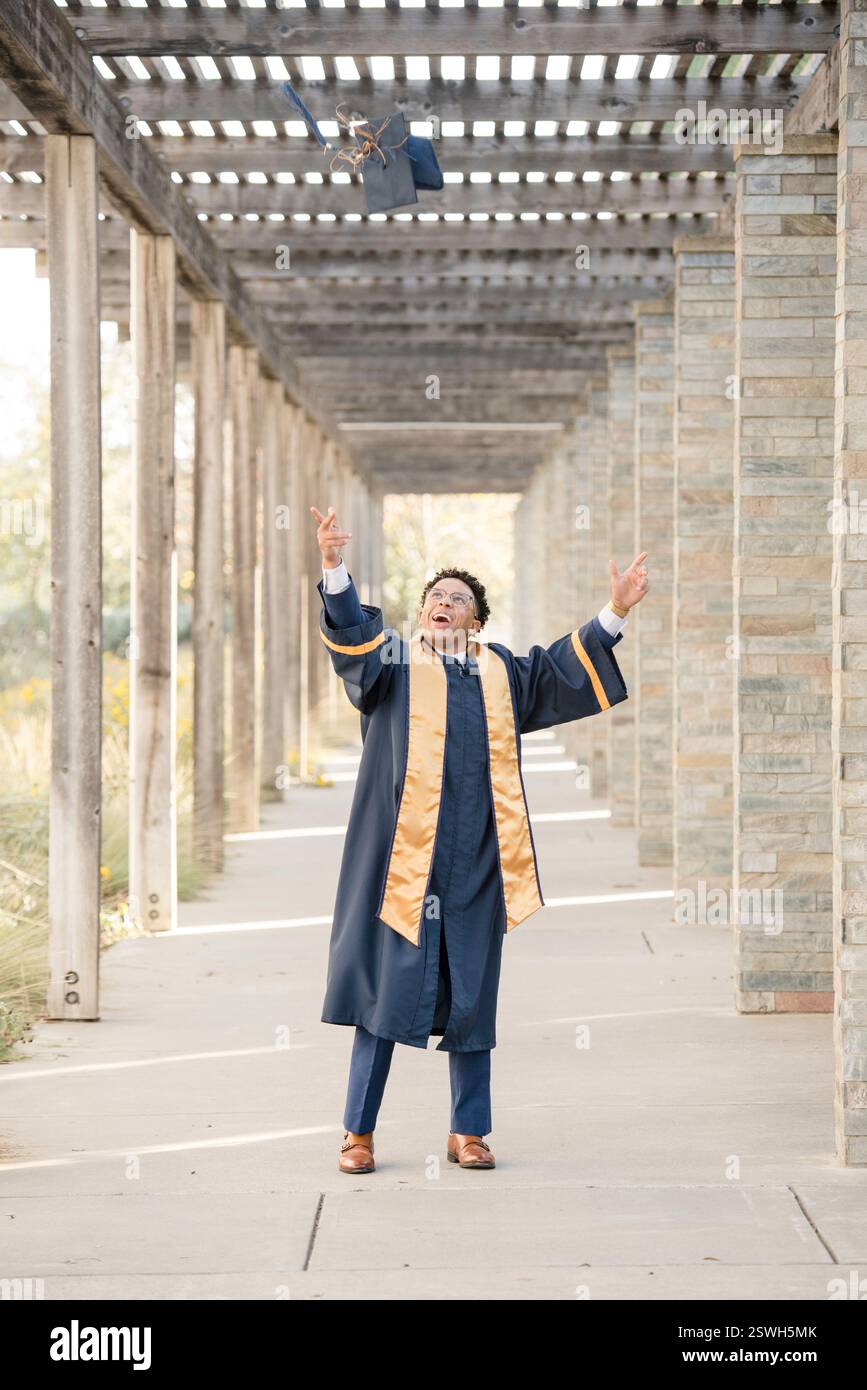College-Absolvent wirft Mütze in die Luft Stockfoto