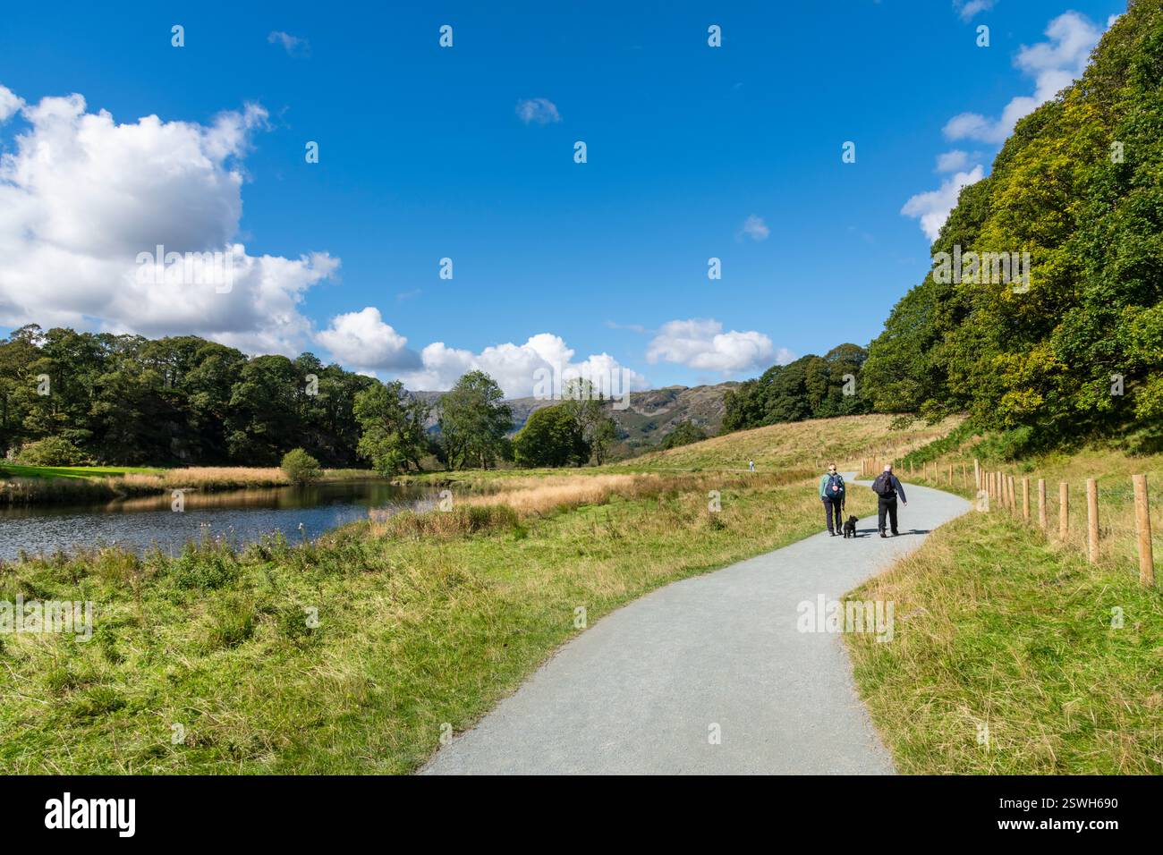 Ein Paar spaziert auf dem Weg nach Elterwater im Lake District Nationalpark, Cumbria, England Stockfoto