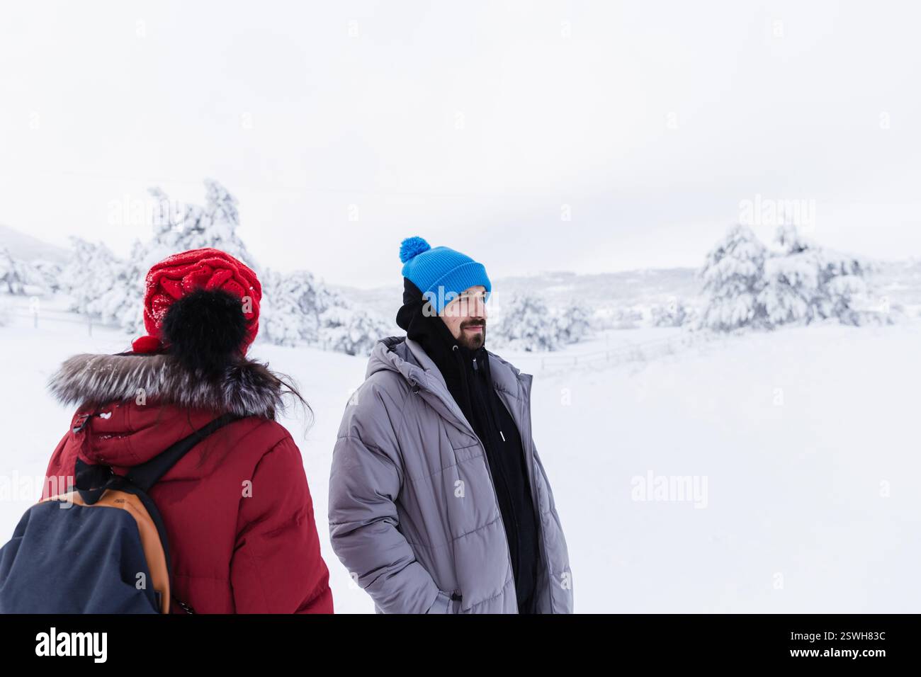 Frau und Mann wandern auf einem schneebedeckten Berggipfel Stockfoto