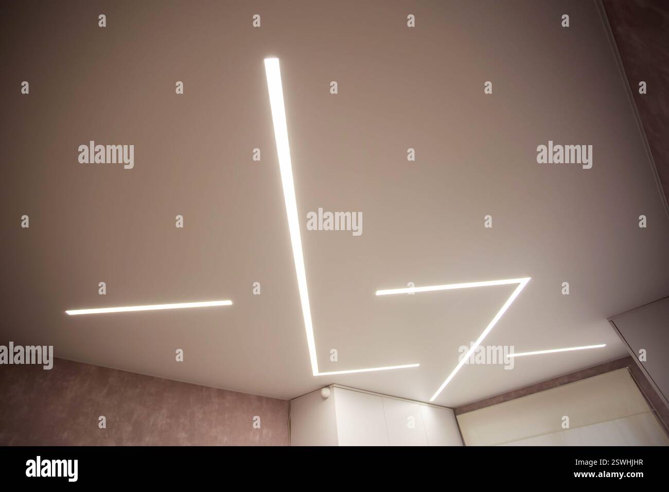 Moderne, stilvolle, dehnbare Decke mit LED-Lichtlinien. Stockfoto