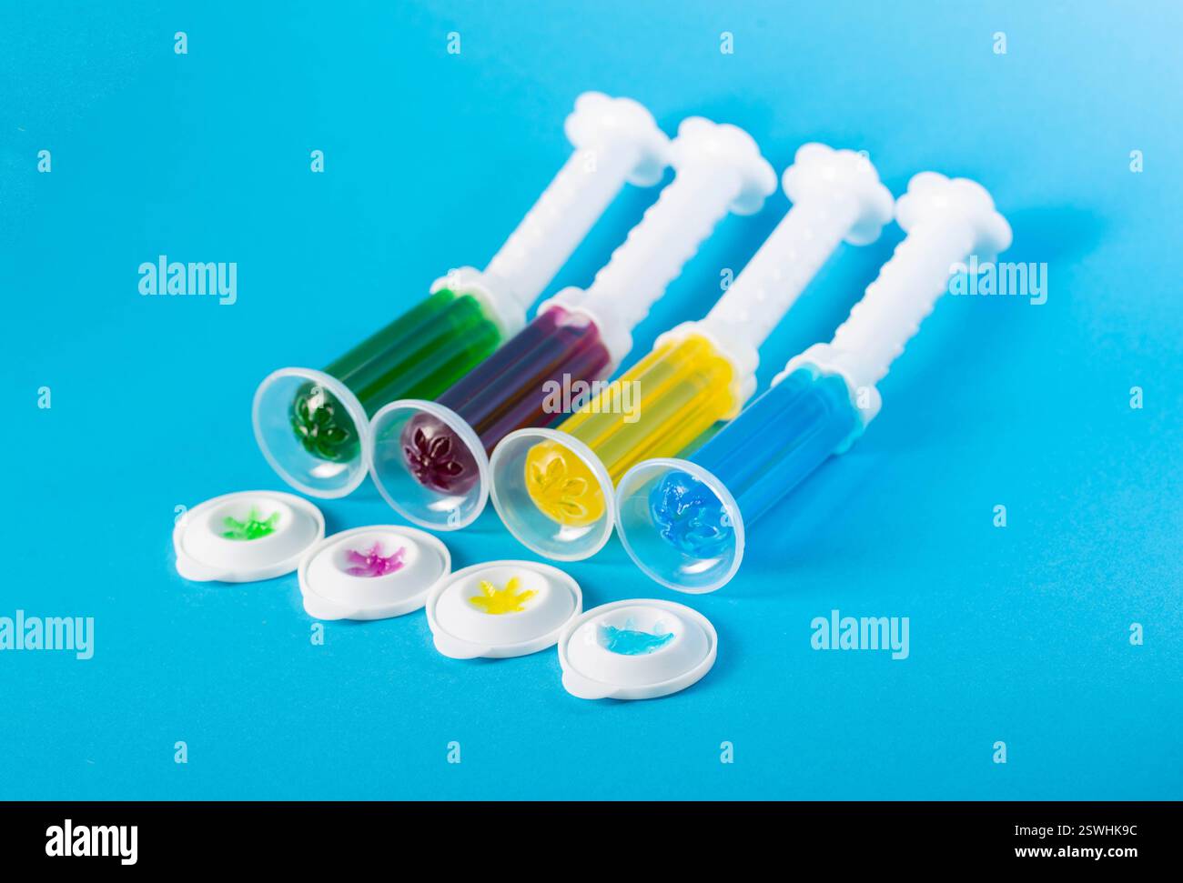 Set aus mehrfarbigen Gelspritzen mit Desinfektionsmittel und Reiniger zur Reinigung der Toilettenschüssel auf blauem Hintergrund, Hygiene. Stockfoto