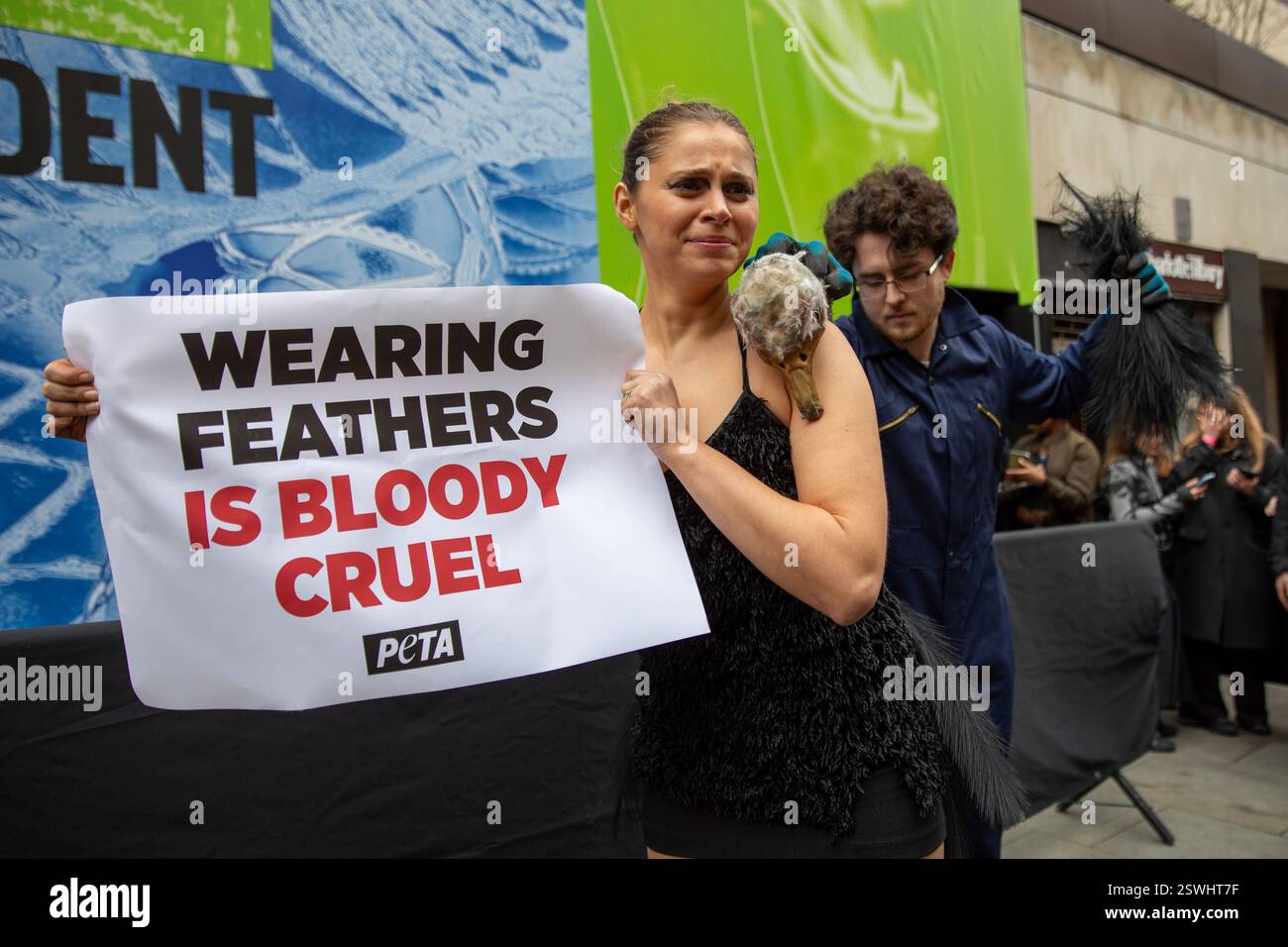 London, UK, 21. Februar 2025. Mitglieder von PETA (People for the Ethical Treatment of Animals) halten eine Demonstration vor einem Veranstaltungsort der Londoner Modewoche ab, in der die Verwendung von Federn in der Bekleidungsindustrie eingestellt wird. Aktivistinnen und Aktivisten stellen die Methode nach, bei der Straußkörperchen gewaltsam gefoltert werden, um Federn für die Herstellung von Kleidungsstücken bereitzustellen. Quelle: James Willoughby/ALAMY Live News Stockfoto