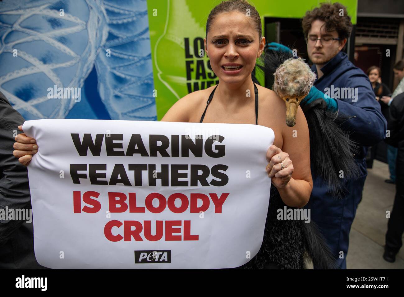 London, UK, 21. Februar 2025. Mitglieder von PETA (People for the Ethical Treatment of Animals) halten eine Demonstration vor einem Veranstaltungsort der Londoner Modewoche ab, in der die Verwendung von Federn in der Bekleidungsindustrie eingestellt wird. Aktivistinnen und Aktivisten stellen die Methode nach, bei der Straußkörperchen gewaltsam gefoltert werden, um Federn für die Herstellung von Kleidungsstücken bereitzustellen. Quelle: James Willoughby/ALAMY Live News Stockfoto