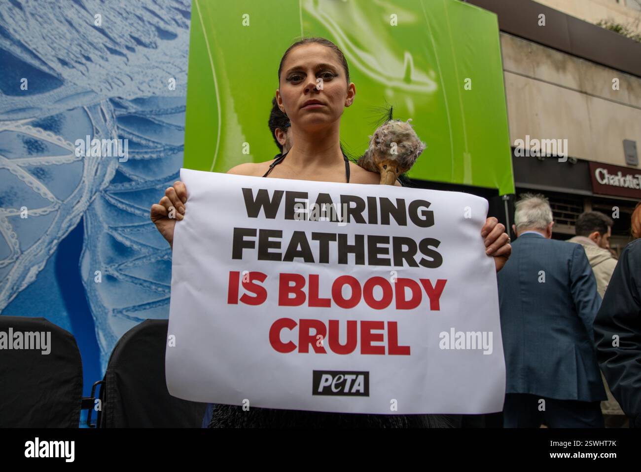 London, UK, 21. Februar 2025. Mitglieder von PETA (People for the Ethical Treatment of Animals) halten eine Demonstration vor einem Veranstaltungsort der Londoner Modewoche ab, in der die Verwendung von Federn in der Bekleidungsindustrie eingestellt wird. Aktivistinnen und Aktivisten stellen die Methode nach, bei der Straußkörperchen gewaltsam gefoltert werden, um Federn für die Herstellung von Kleidungsstücken bereitzustellen. Quelle: James Willoughby/ALAMY Live News Stockfoto