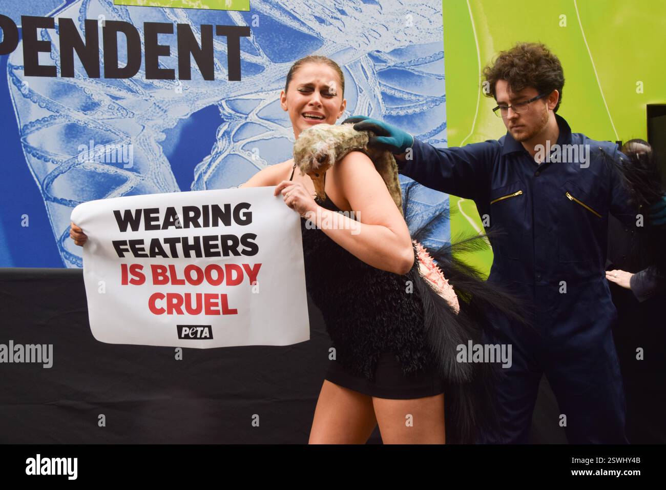London, Großbritannien. Februar 2025. Eine PETA-Aktivistin, die als Strauß verkleidet ist, lässt ihre Federn vor der London Fashion Week NEWGEN Show Space on the Strand „heftig zupfen“. Die Aktion ist Teil der laufenden PETA-Kampagne gegen den Einsatz von Federn in der Mode. Quelle: Vuk Valcic/Alamy Live News Stockfoto