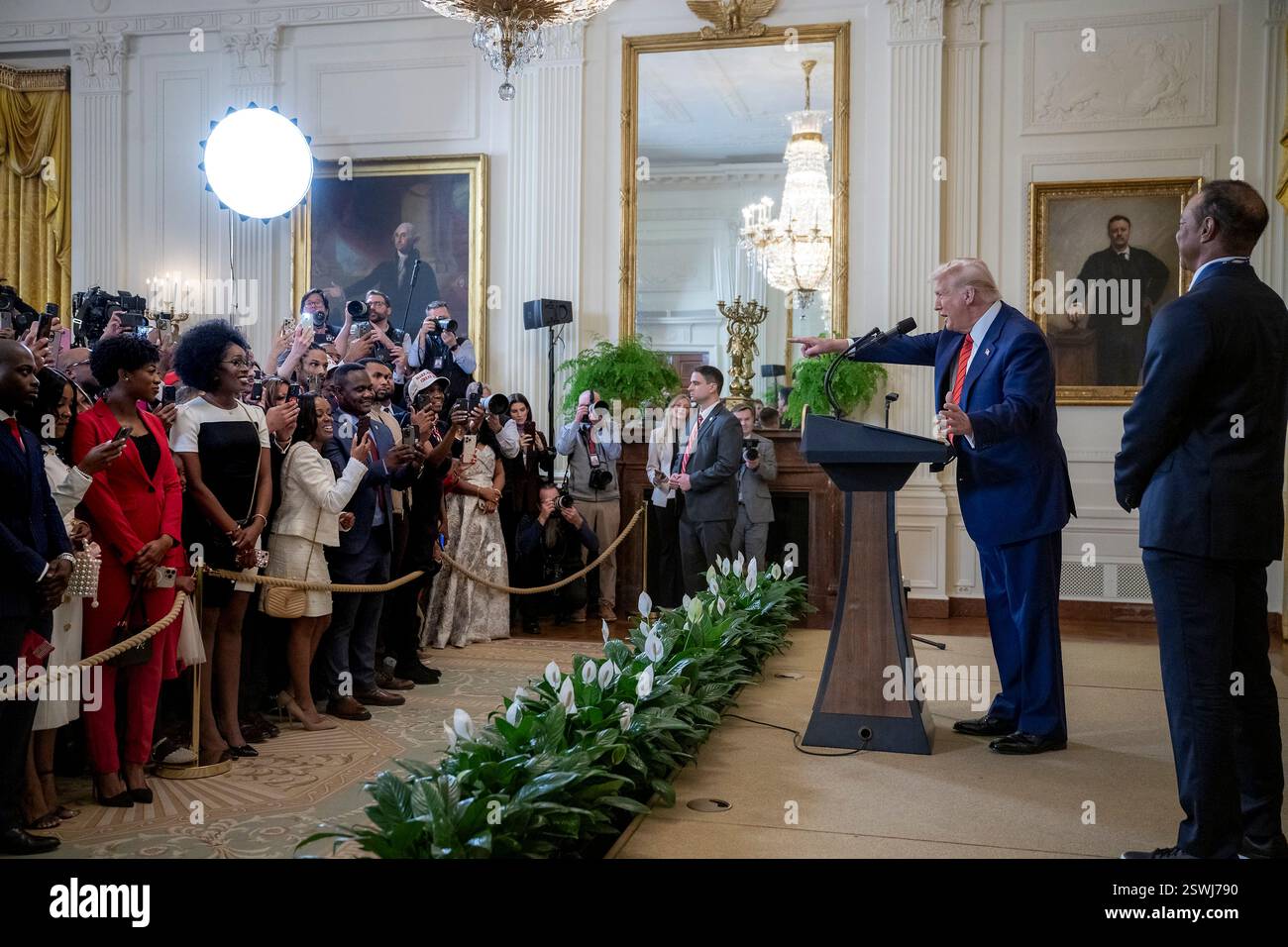 Washington, Usa. Februar 2025. U. US-Präsident Donald Trump, links, mit Golflegende Tiger Woods, rechts, hält Bemerkungen während eines Black History Month Events im East Room of the White House, 20. Februar 2025 in Washington, DC. Credit: Daniel Torok/White House Photo/Alamy Live News Stockfoto