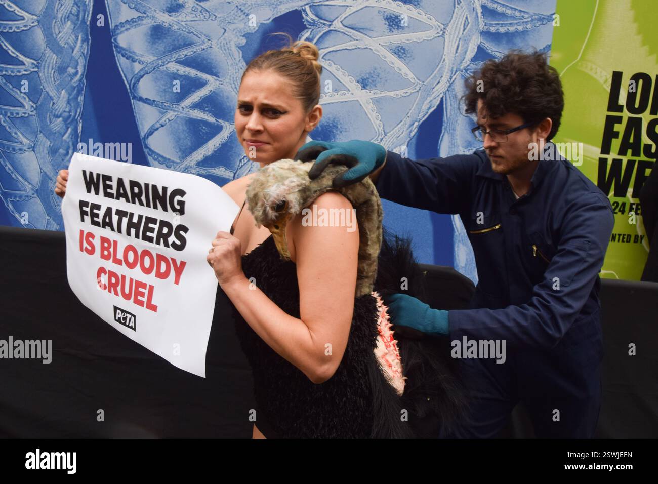 London, Großbritannien. Februar 2025. Eine PETA-Aktivistin, die als Strauß verkleidet ist, lässt ihre Federn vor der London Fashion Week NEWGEN Show Space on the Strand „heftig zupfen“. Die Aktion ist Teil der laufenden PETA-Kampagne gegen den Einsatz von Federn in der Mode. Quelle: Vuk Valcic/Alamy Live News Stockfoto