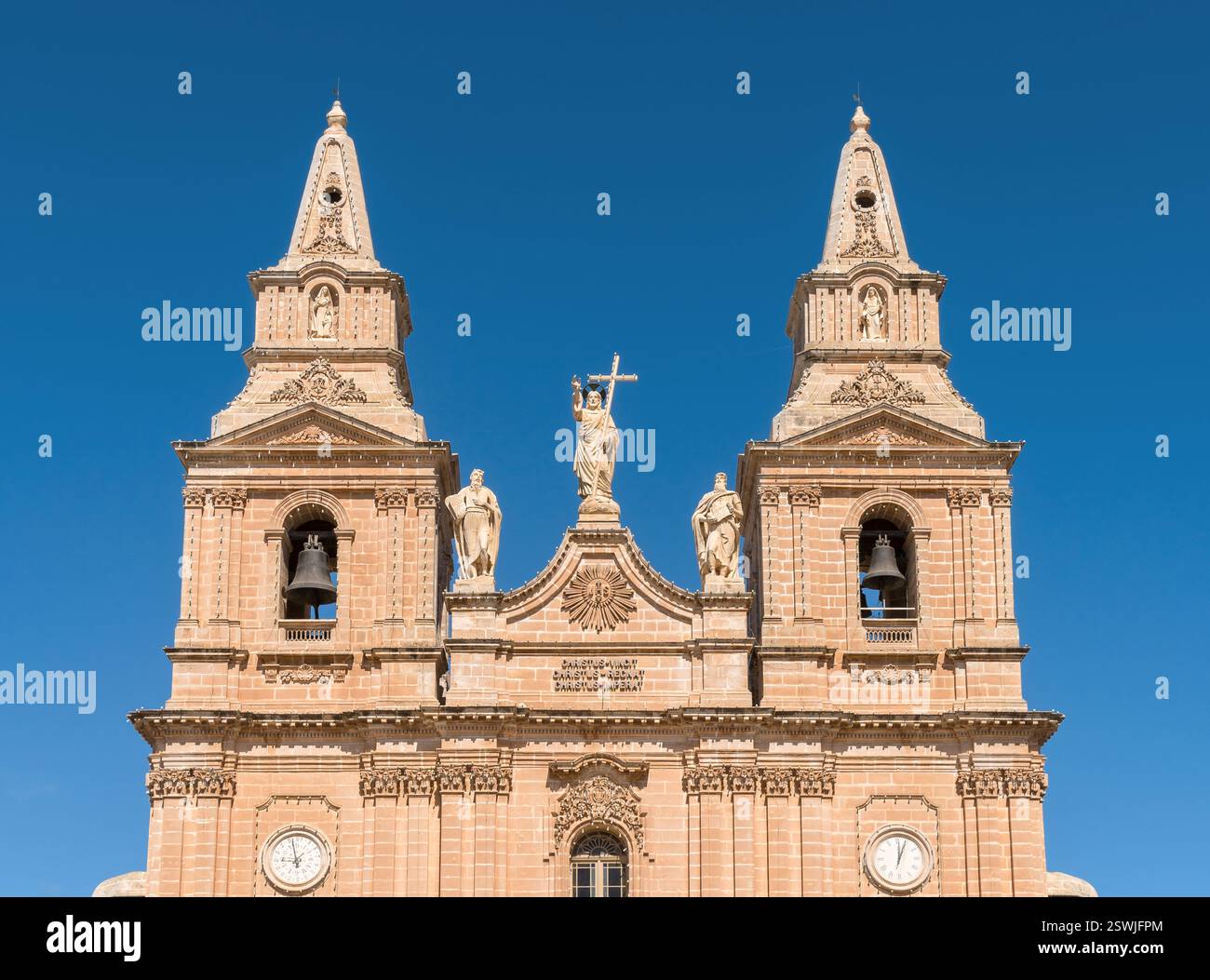 Kirchenfassade mit zwei Glockentürmen, Statuen und lateinischer Inschrift - Mellieha, Malta. Stockfoto