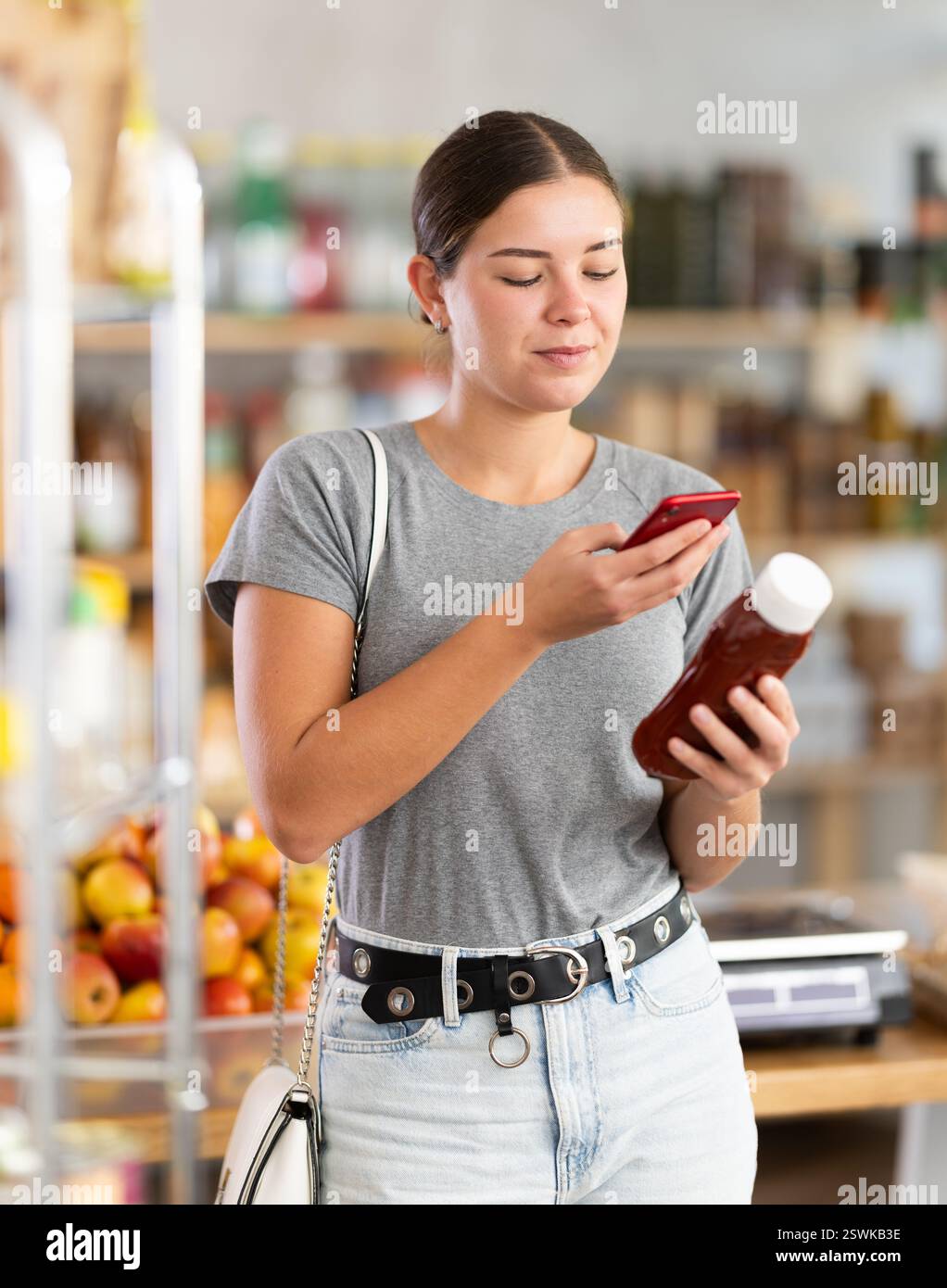 Frau, die ein Paket Ketchup scannt Stockfoto
