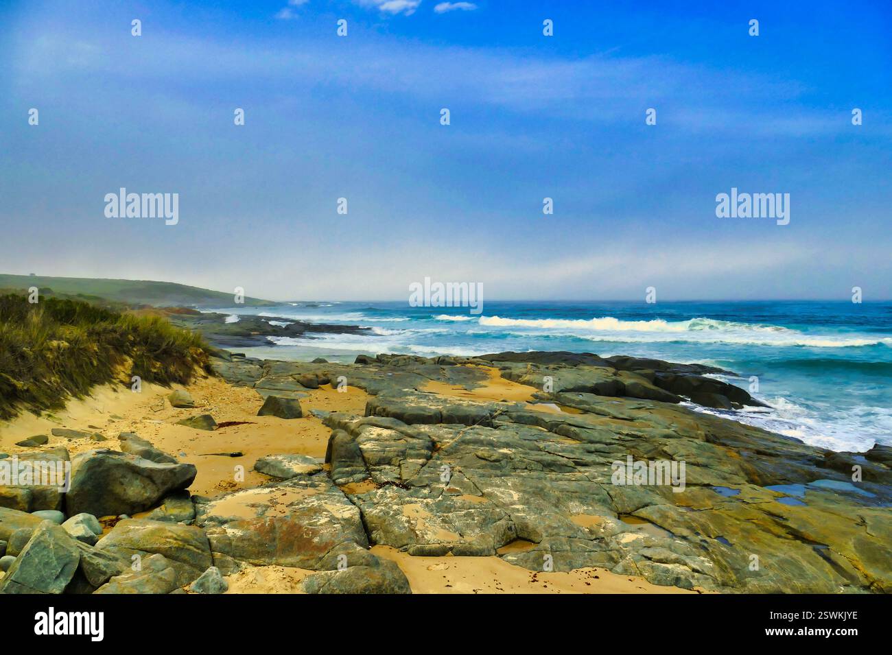Wilde Granit- und Sandküste mit brechenden Wellen. Lagoon Beach, an der Ostküste Tasmaniens, Australien Stockfoto