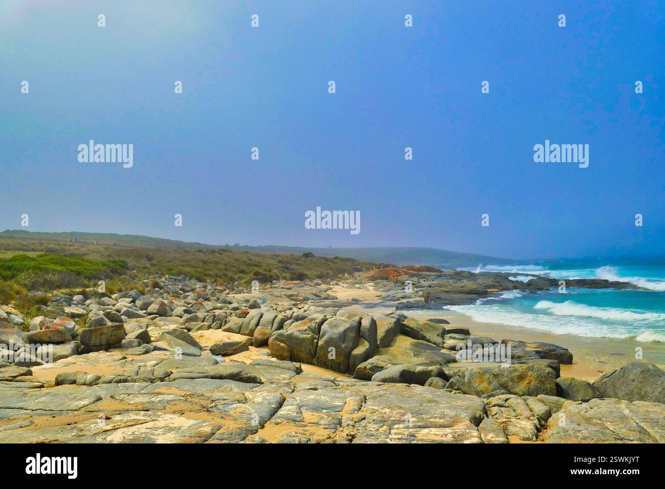 Wilde Granit- und Sandküste mit brechenden Wellen. Lagoon Beach, an der Ostküste Tasmaniens, Australien Stockfoto