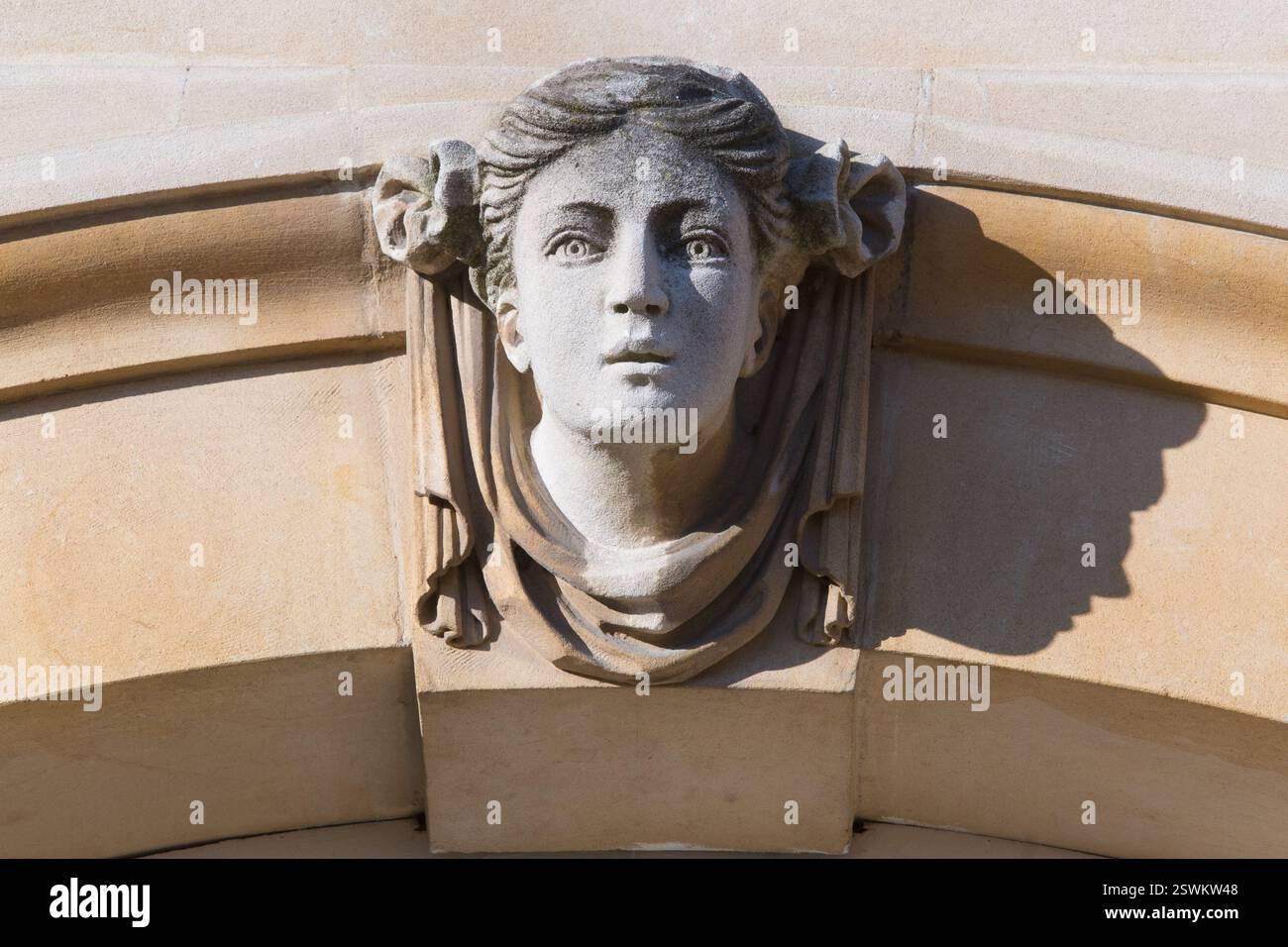Steinschnitzereien in den Kopf einer Frau, wahrscheinlich ein dekoratives Element, zieren den Torbogen des Hampton Court Palace. Stockfoto