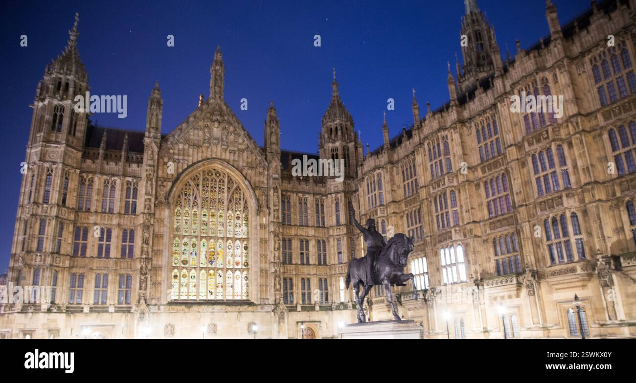 Nachtansicht auf den Palast von Westminster, London, Großbritannien. Statue von König Georg III. Berühmtes Wahrzeichen. Stockfoto