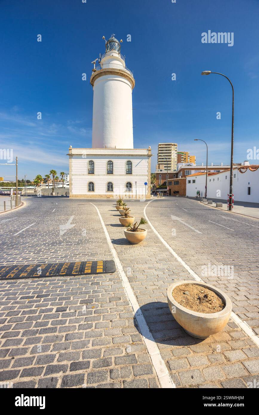 Malaga, Küstenstadt in Andalusien, Spanien, Europa. Der Küstenleuchtturm steht hoch vor einem hellblauen Himmel. Kopfsteinpflasterstraßen und Topfpflanzen kommen hinzu Stockfoto