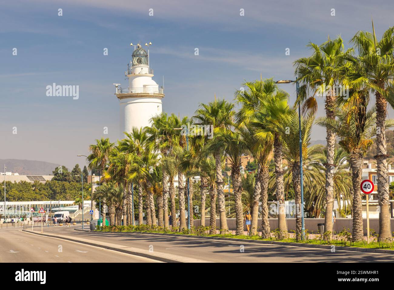 Malaga, Küstenstadt in Andalusien, Spanien, Europa. Leuchtturm und Palmen säumen eine sonnige Küstenstraße. Eine ruhige Küstenszene. Stockfoto
